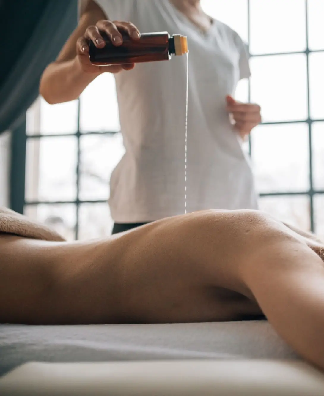 Solène verse de l’huile tiède avant un massage